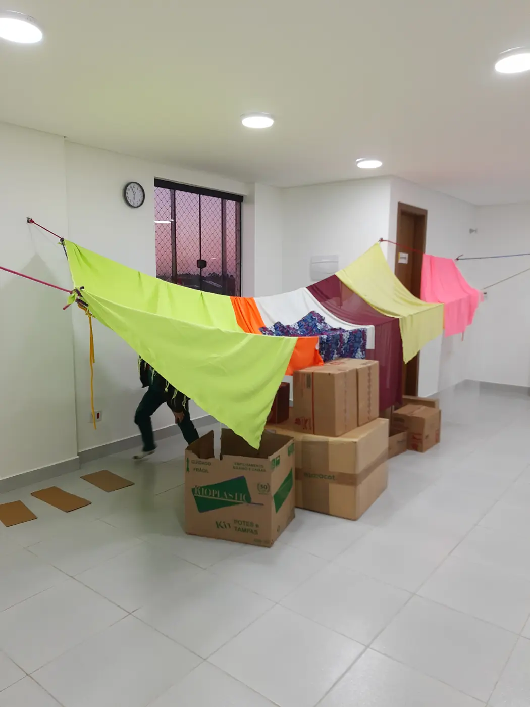 Cabana montada com tecidos coloridos e caixas de papelão durante uma sessão de brincar espontâneo
